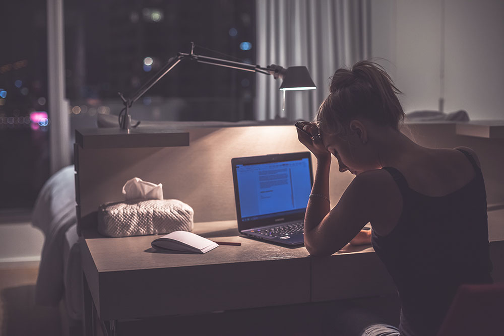 tired woman working on computer on desk