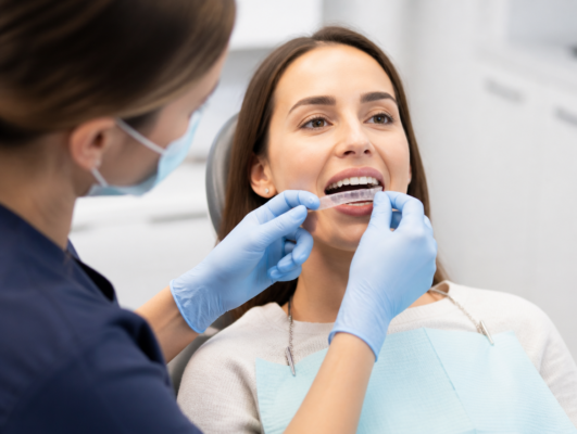 Dentist fitting a custom TMJ disorder orthotic